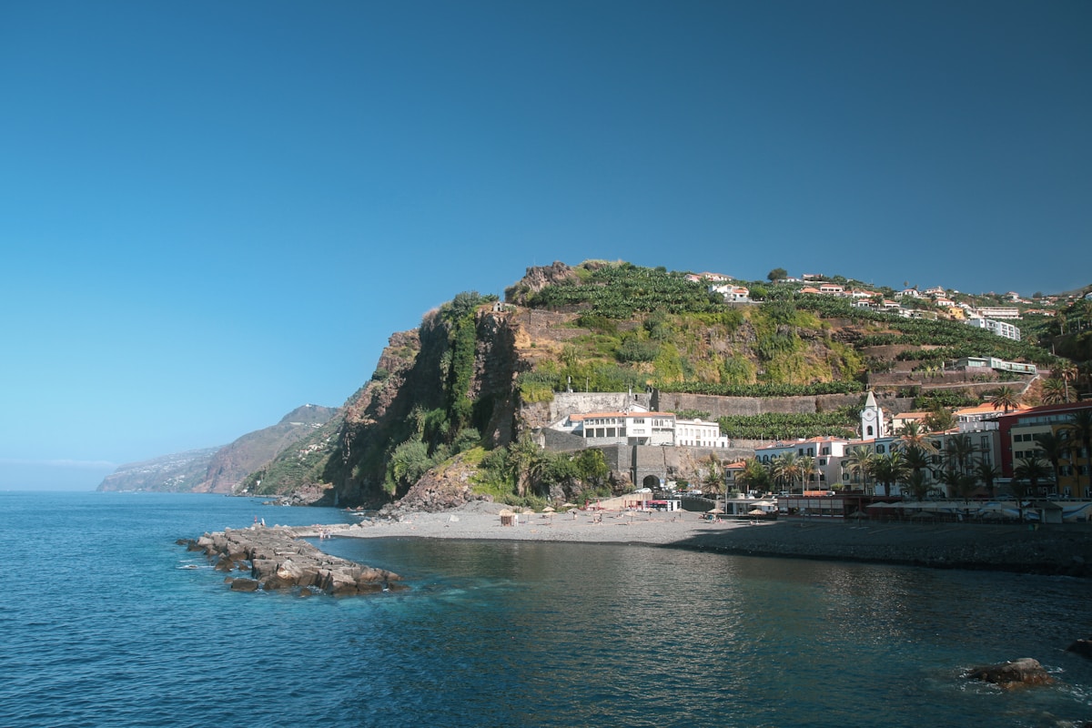 Coastal village on Madeira’s steep volcanic hillside, with terraced slopes rising from the Atlantic. Photo by Lea Poisson on Unsplash